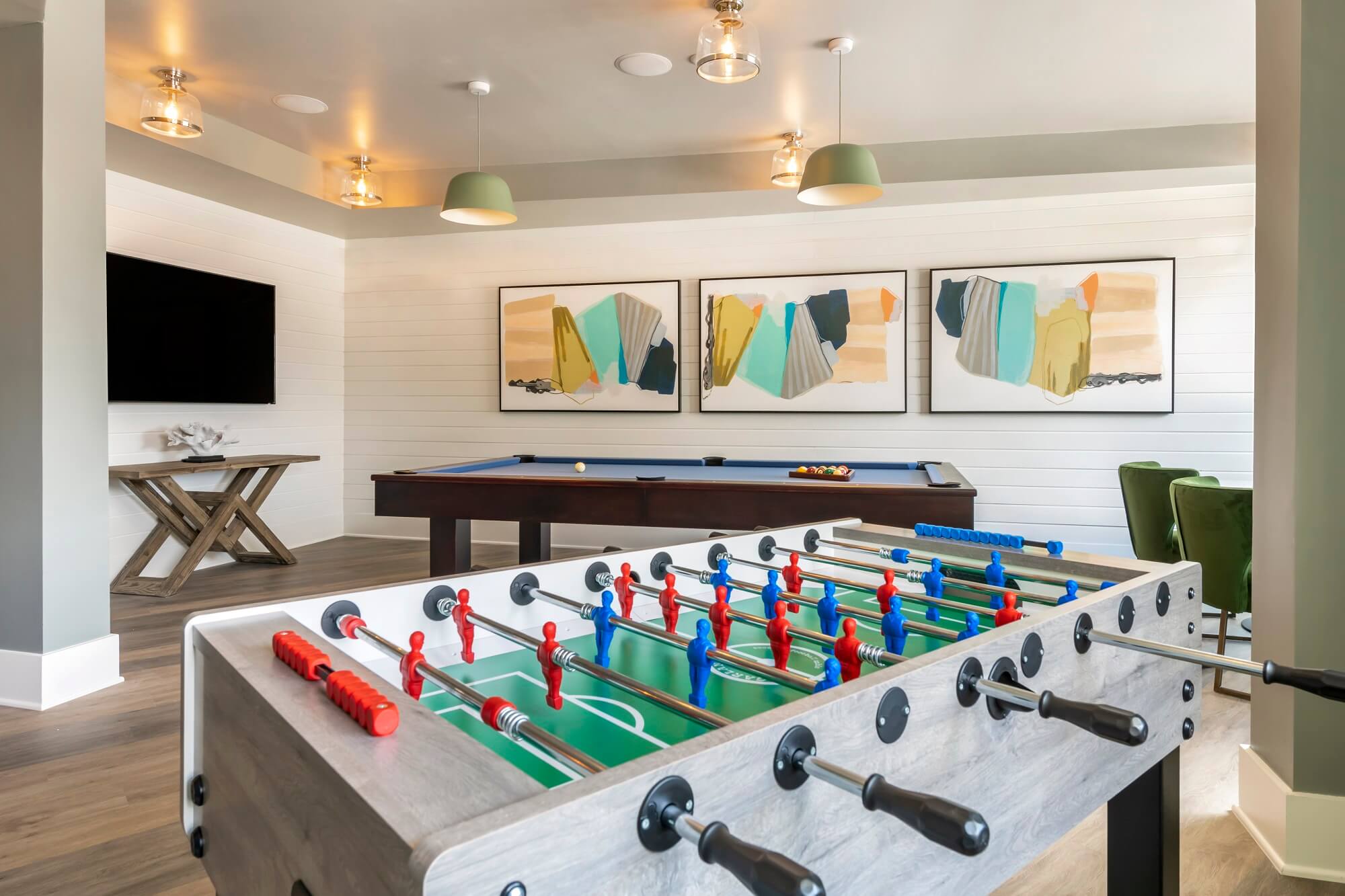 Clubhouse game room with foosball table, billiards, and TV