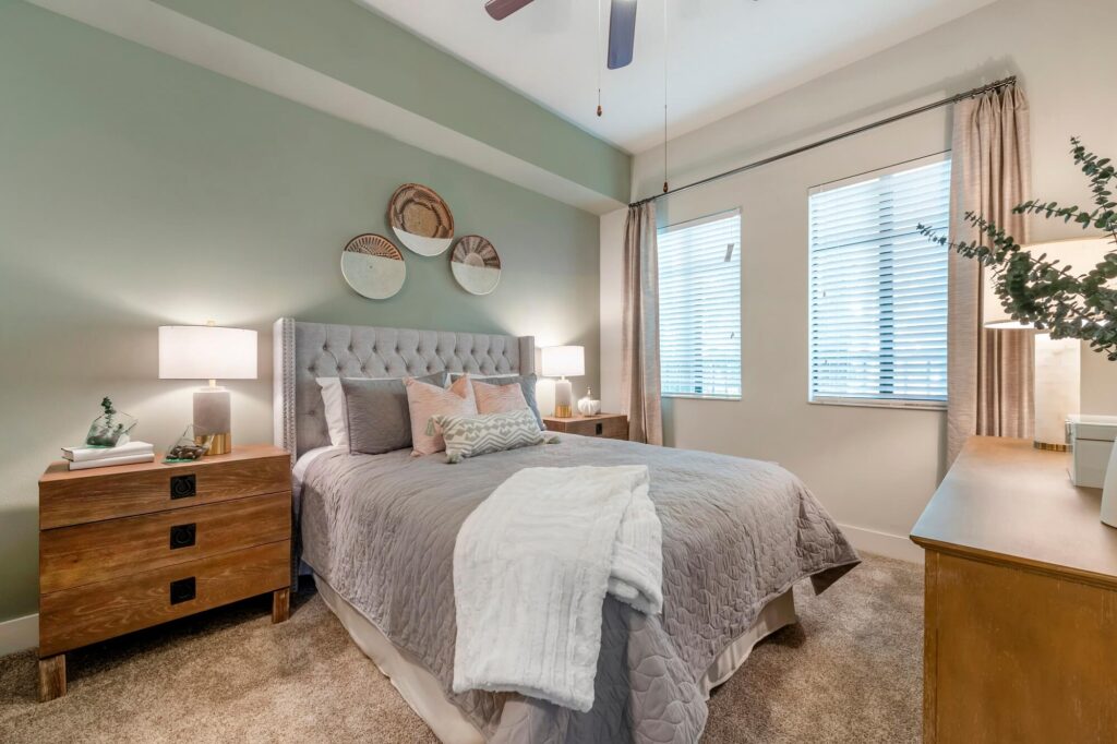 Model bedroom with large windows and ceiling fan