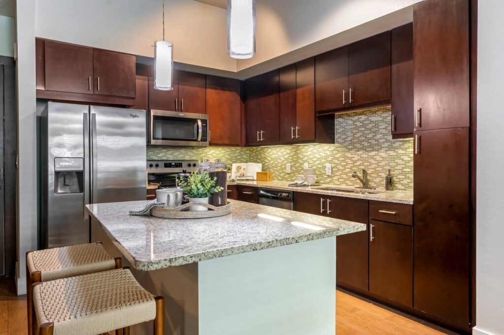 Kitchen with granite countertops, stainless steel appliances, and tile backsplash